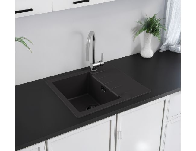 Popolnoma črno kuhinjsko korito z inox armaturo v moderni kuhinji s črnim kuhinjskom pultom in sobno rastlino na njem